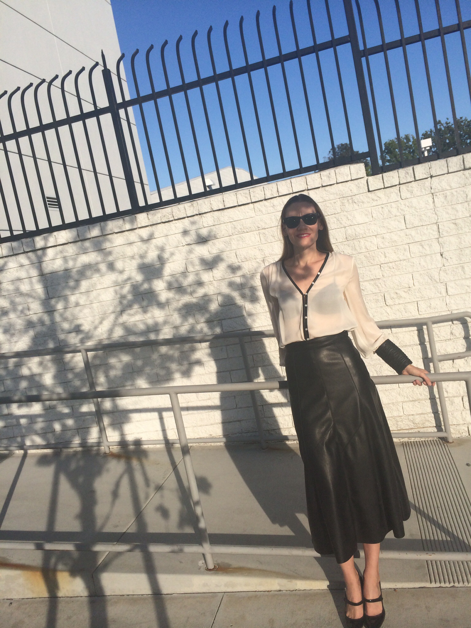 a woman in a leather midi skirt and sheer blosue