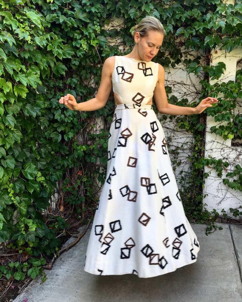 a woman in a white and brown flit and flare dress