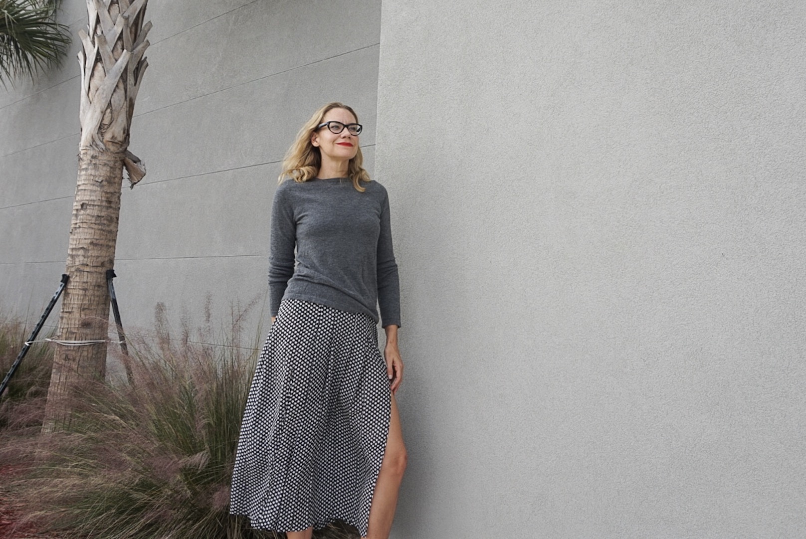 a woman in a silk midi skirt and cashmere sweater