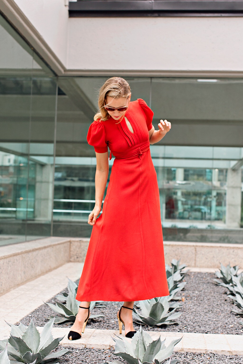 A woman in a red dress and black velvet heels