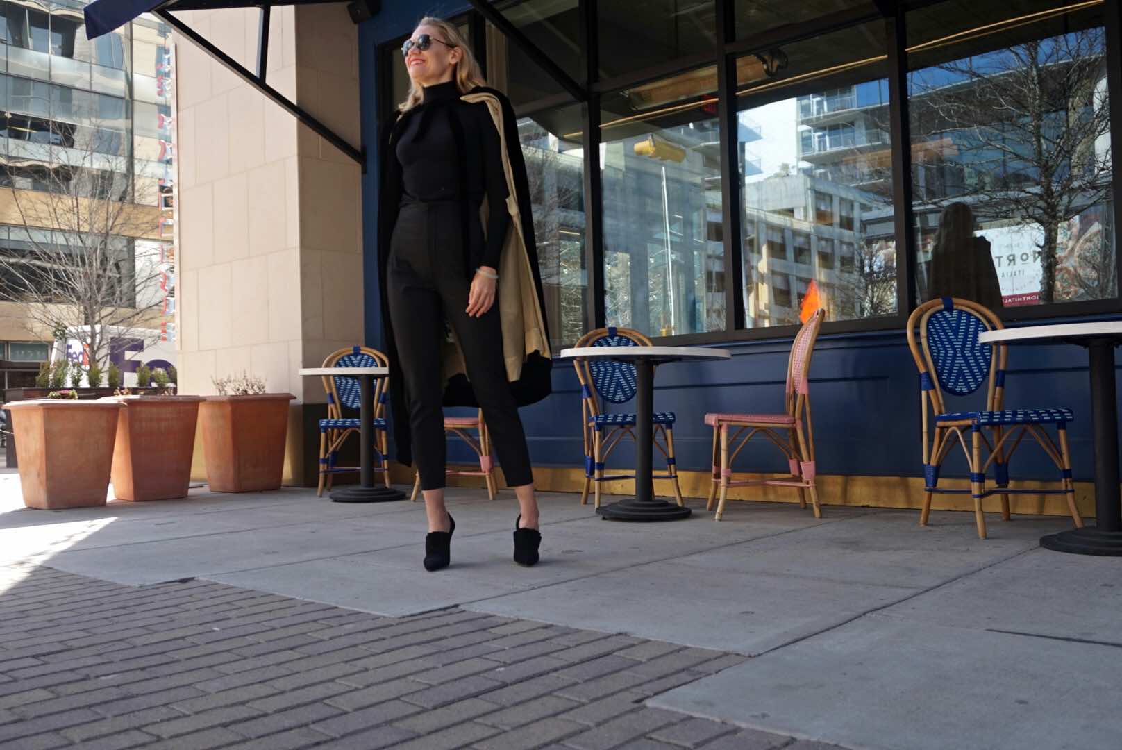 a woman in black pants and turtleneck, heels and black velvet cape