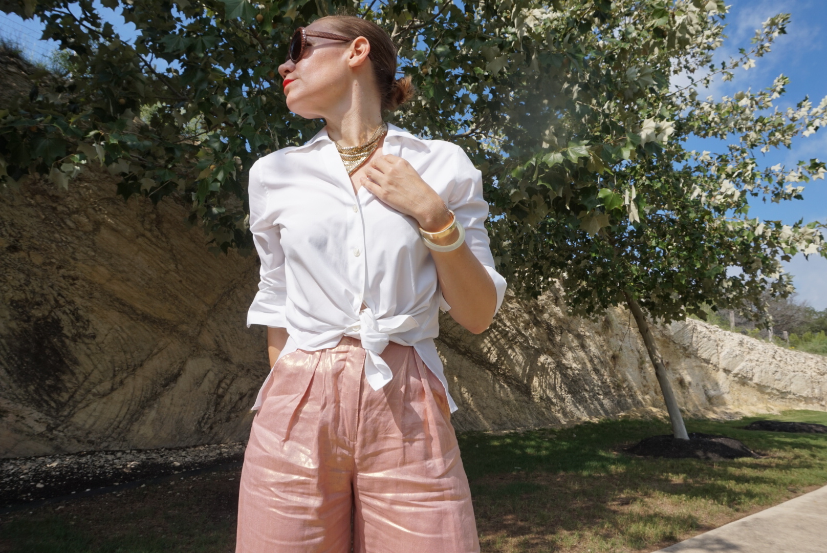 a woman in a white button down and rose gold pants