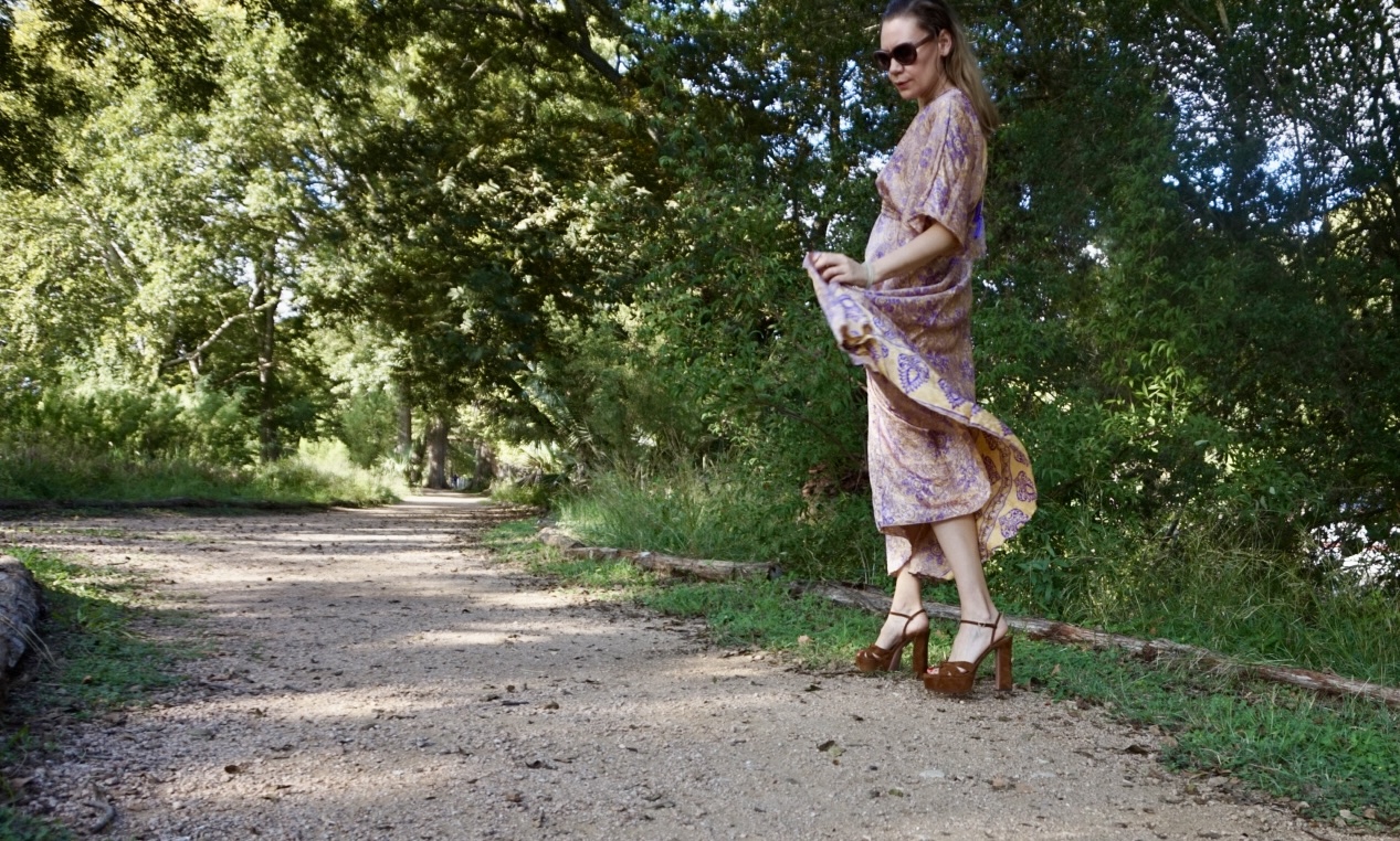a woman in a gold and purple caftan and platform shoes