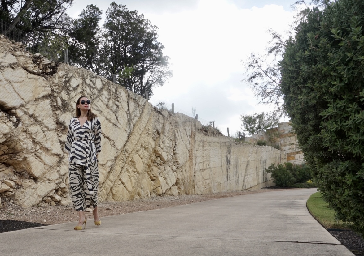 a woman in a zebra suit in a front of a stone wall