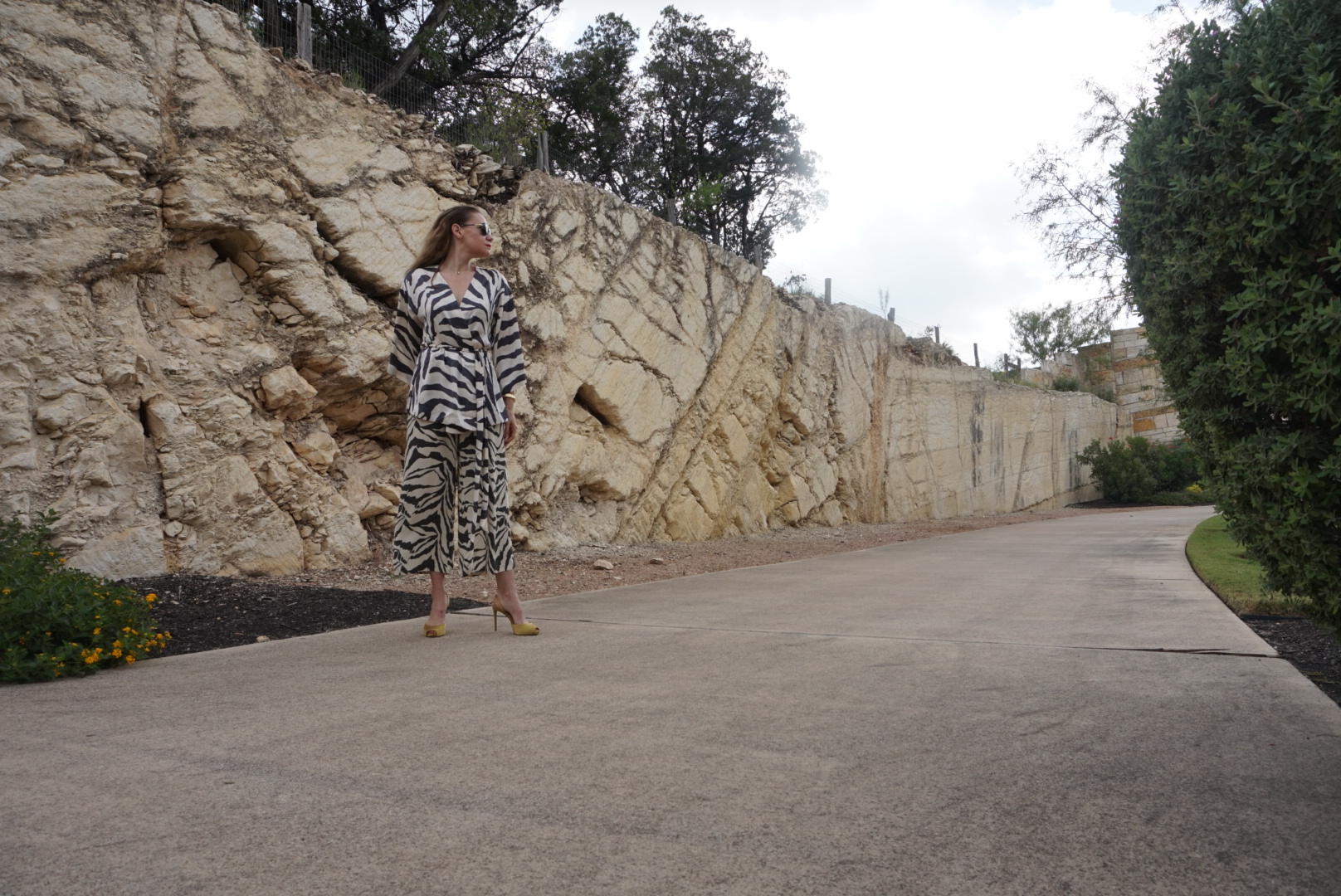a woman in a zebra suit in front of a stone wall