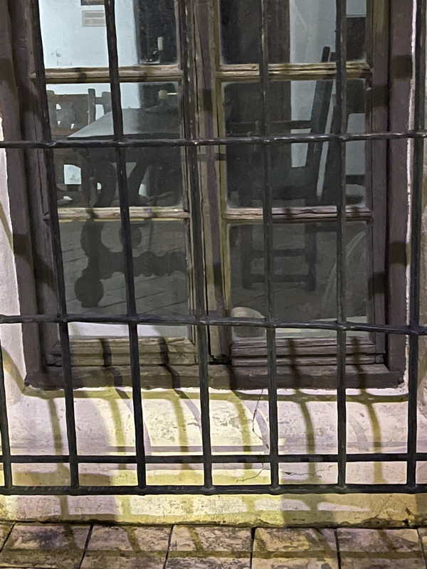 a window with bars on it. You may be able to see a ghost in it!