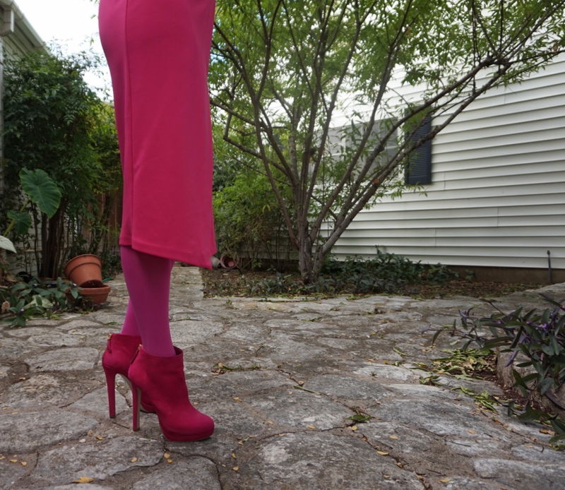 a woman in a hot pink dress, tights and boots
