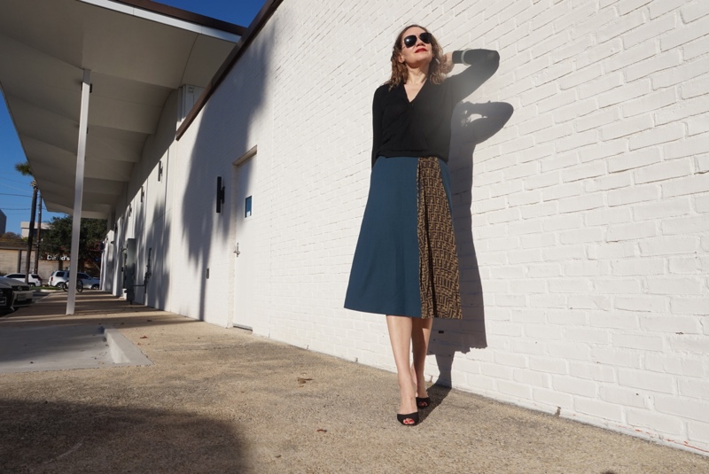 a woman in a wool skirt with a black sweater and shoes