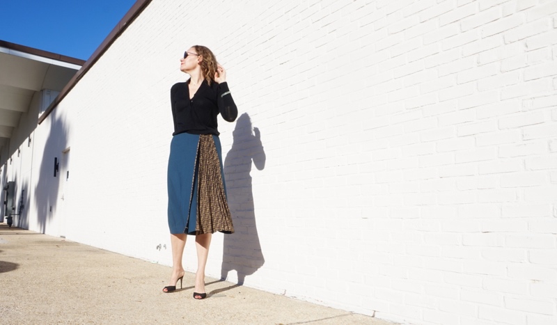 a woman in a blue wool skirt with black sweater and heels