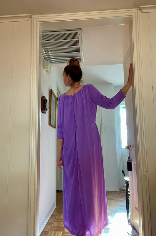 a woman in a purple hostess dress in a doorway 