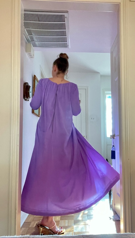 a woman in a purple cape dress spinning