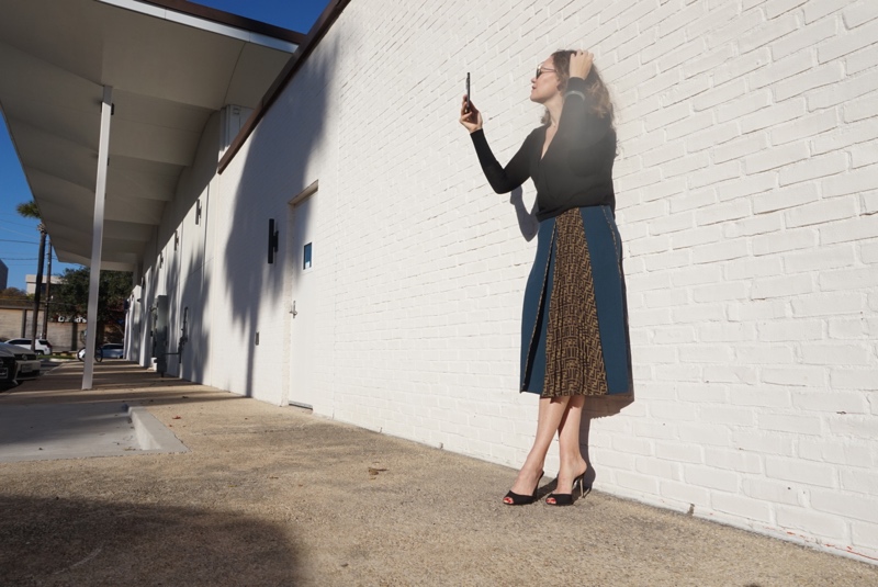 a woman in a blue wool skintand black sweater and heels