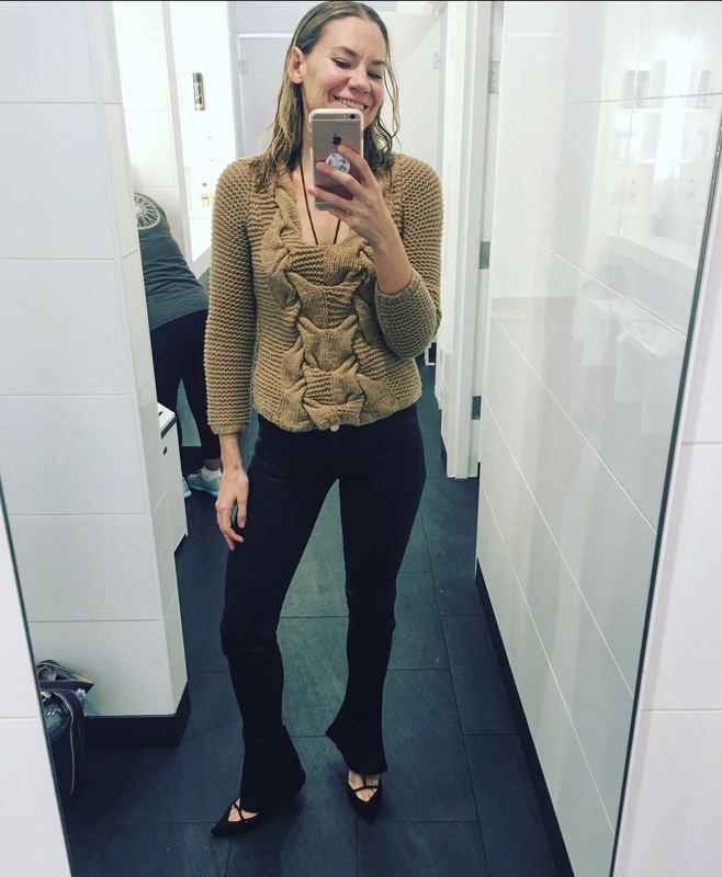a woman in black jeans and a camel sweater