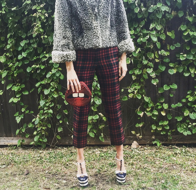 a woman in a cropped fur jacket, plaid pants, and platforms