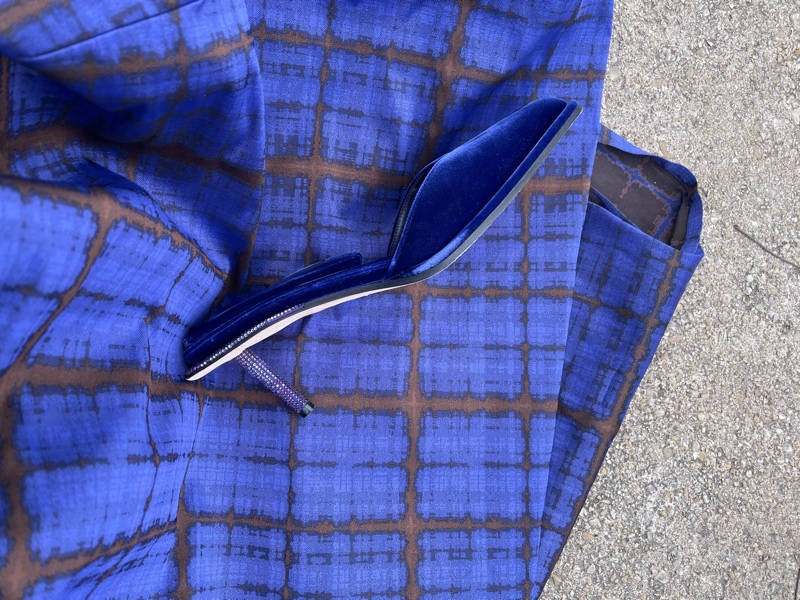 a close up of a purple plaid gown and purple and rhinestone mules with heels 