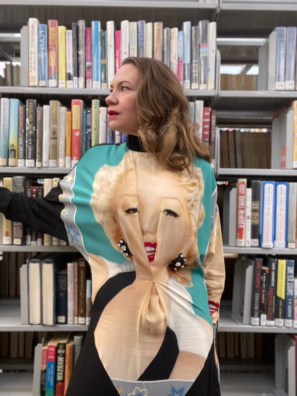 a woman in a black dress with eh face of Marilyn Monroe on it in Library Stacks