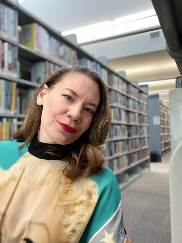 a woman in Marilyn Monroe Print dress on the library stacks 