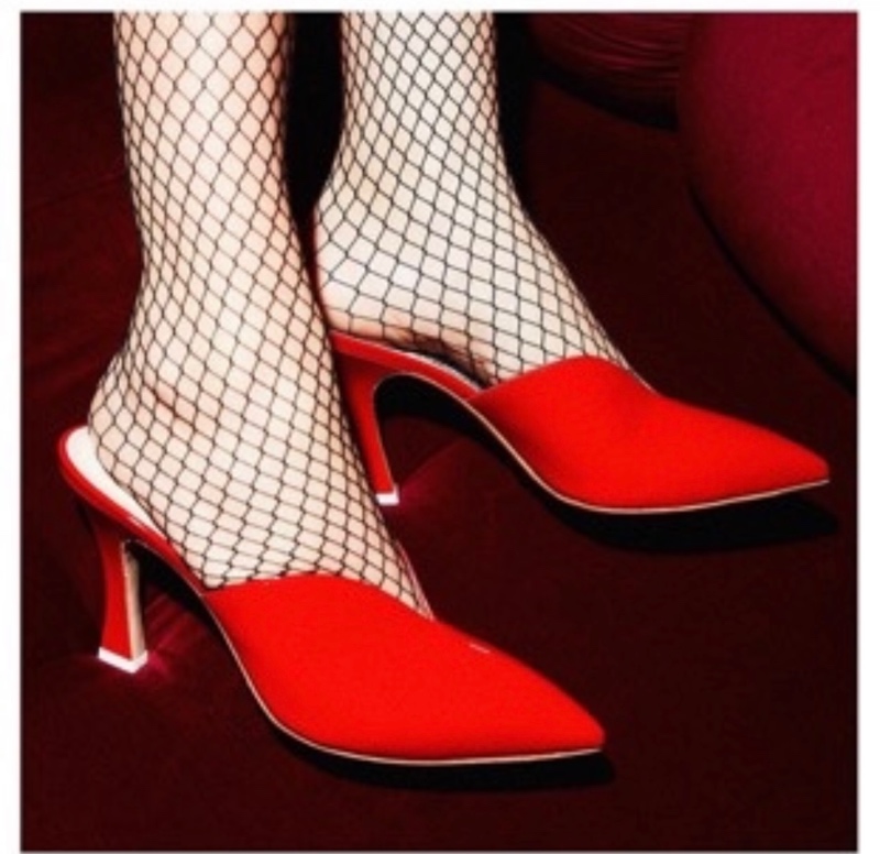 close up of feet in fishnet stockings and red heeled mules