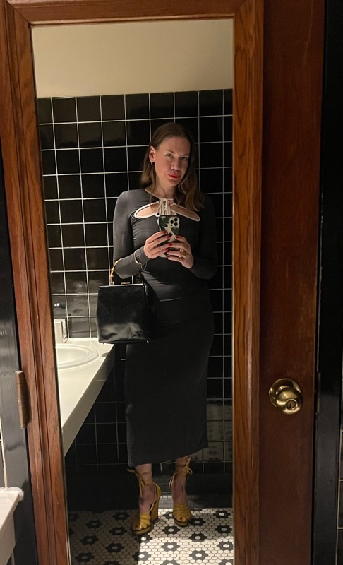 a woman in a jersey dress in a mirror in a bathroom
