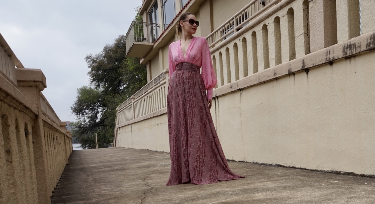 a woman in a pink and red maxi gown with pink wedge heels 
