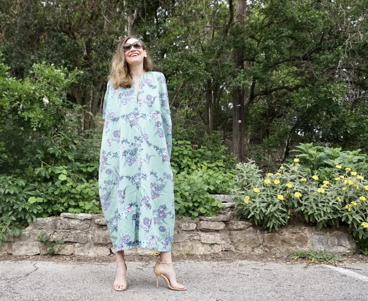 a woman in a green floral caftan with heels