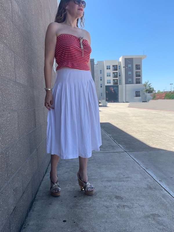 a woman in a red and white tube top with a leopard brooch and a white skirt and leopard wedges 
