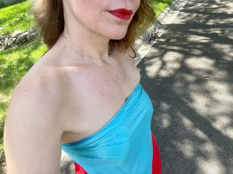 a woman in a light blue and red strapless dress in the middle of the road