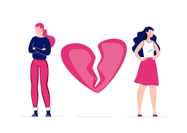 two women- one in red pants and a black top with red hair and one in a pink skirt and white top with black hair stand on either side of a broken pink and red heart