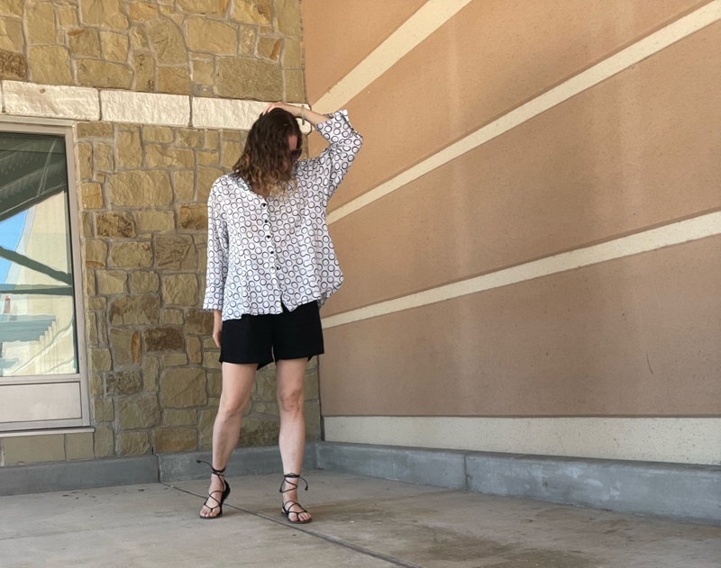 a woman in oversized linen shorts and top with lace up sandals