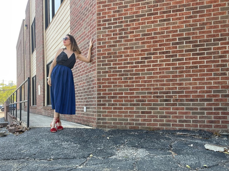 a woman in a blue striped midi, grey strappy top and red lace up heels