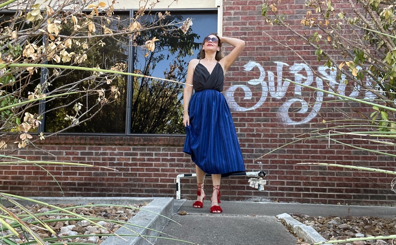 a woman in a blue striped midi skirt, grey strappy top and red lace up heels