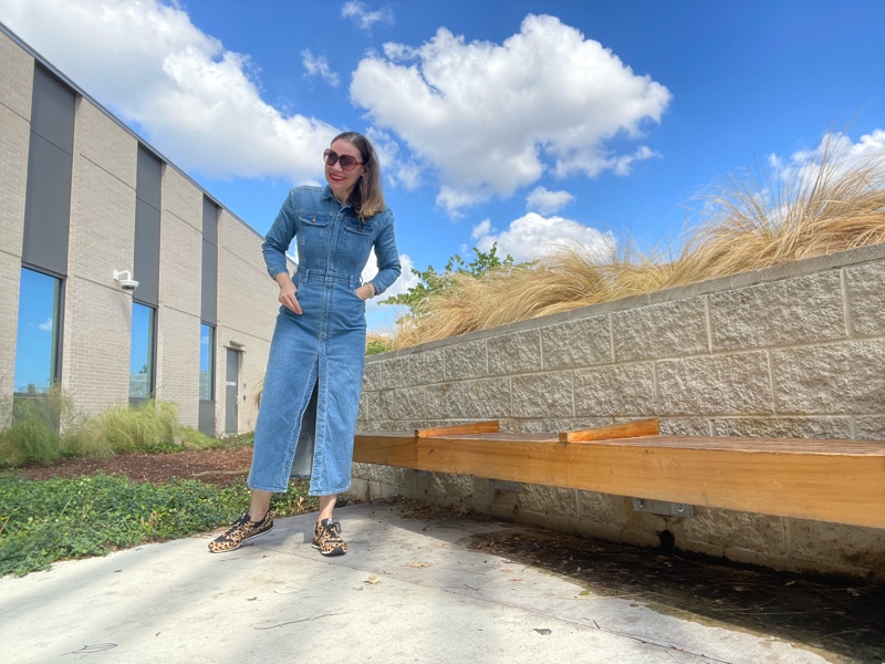 a woman in a denim maxi dress and leopard sneakers