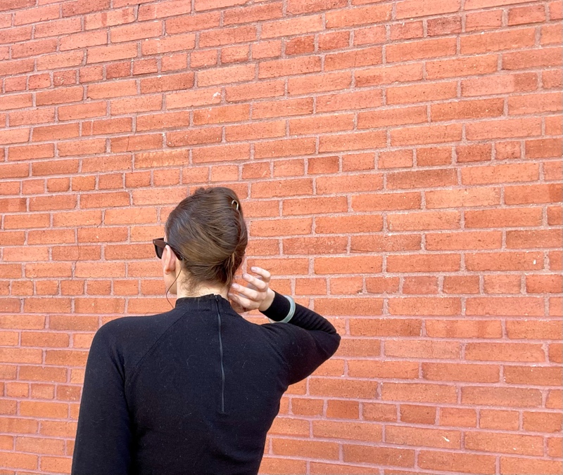 the back of a woman's hard and her hair in a French twist with a black turtleneck