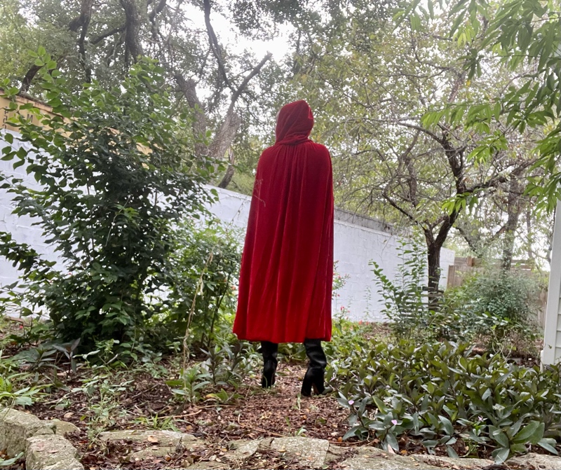 a woman in a red cape and black boots