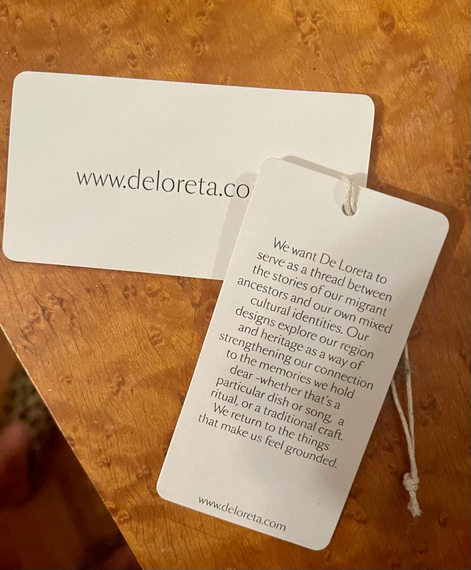 a tag that reads: We want De Loreta to serve as a thread between the stories of our migrant ancestors and our own mixed cultural identities. Our designs explore our region and heritage as a way of strengthening our connection to the memories we hold dear -whether that's a particular dish or song, a ritual, or a traditional craft. We return to the things that make us feel grounded.