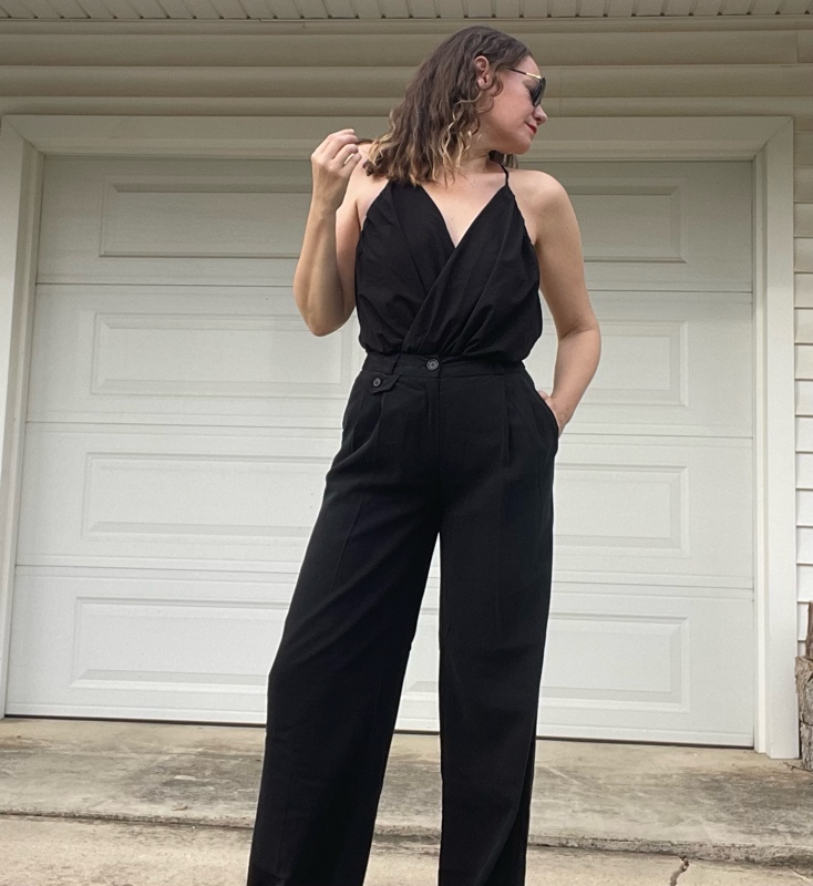 a woman in a black v neck, black trousers, and pink mules