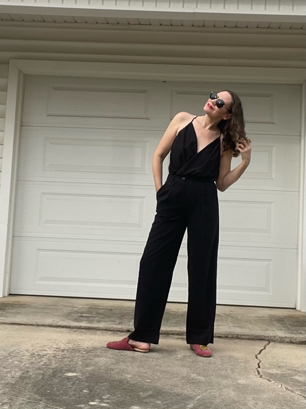 a woman in a v neck and black trousers and pink mules