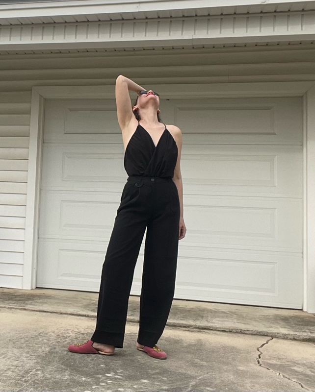 a woman in a v neck and black trousers with pink mules