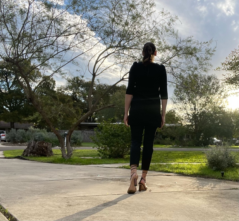 a woman in black mini dress over cropped black pants and asymmetrical shoes