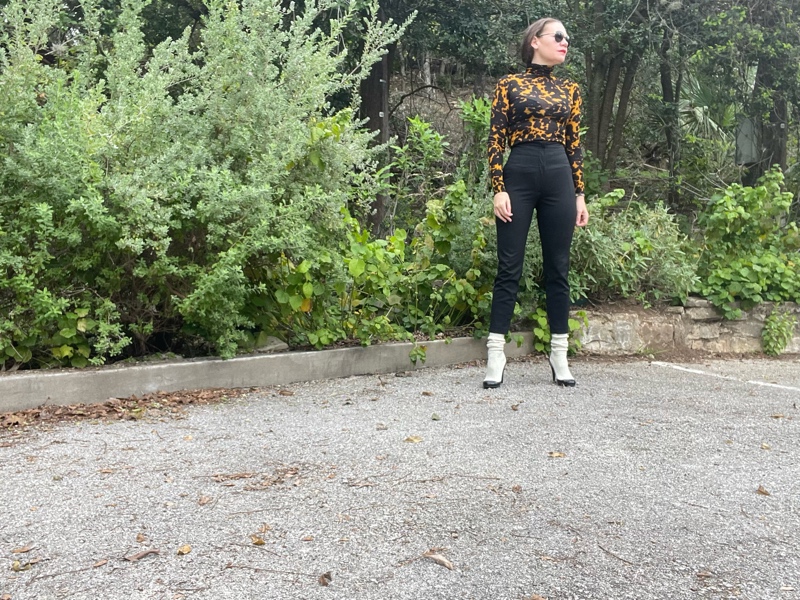 a woman in a tortoiseshell turtleneck and black high waisted cropped pants and white sock boots