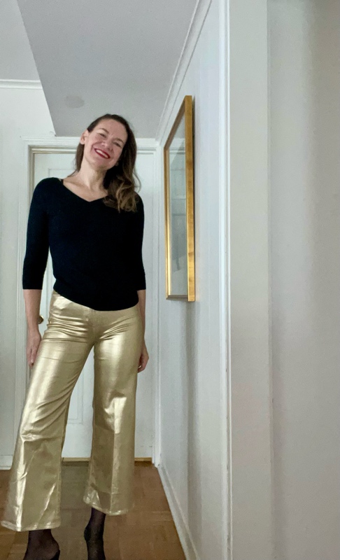 a woman in Gold Pants and a black sweater