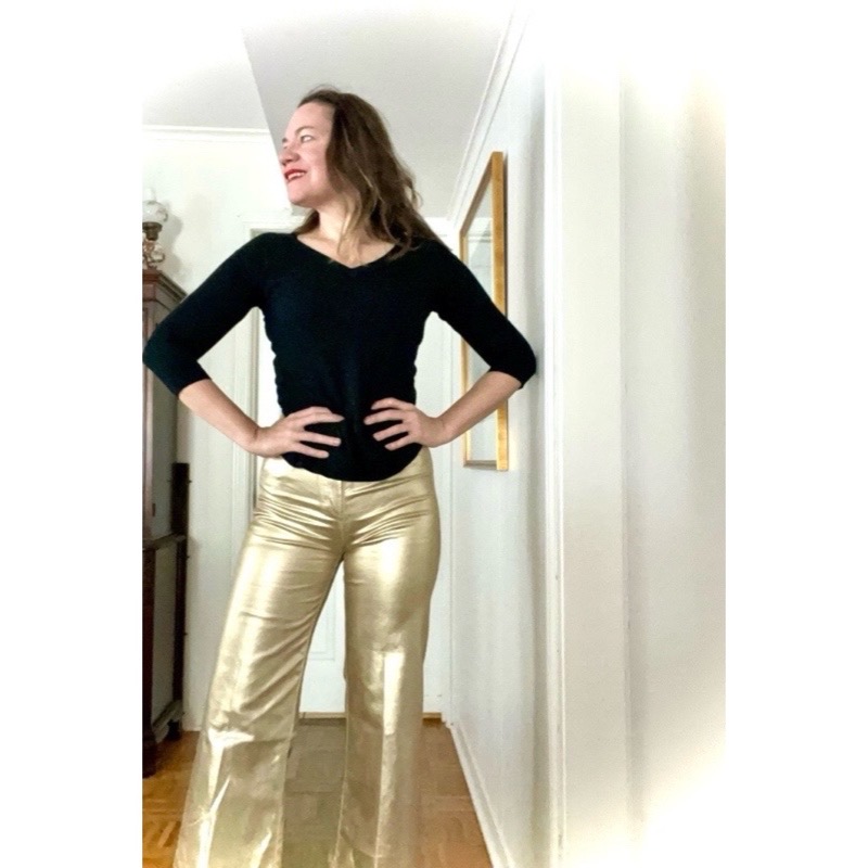 a woman in gold pants and a black sweater