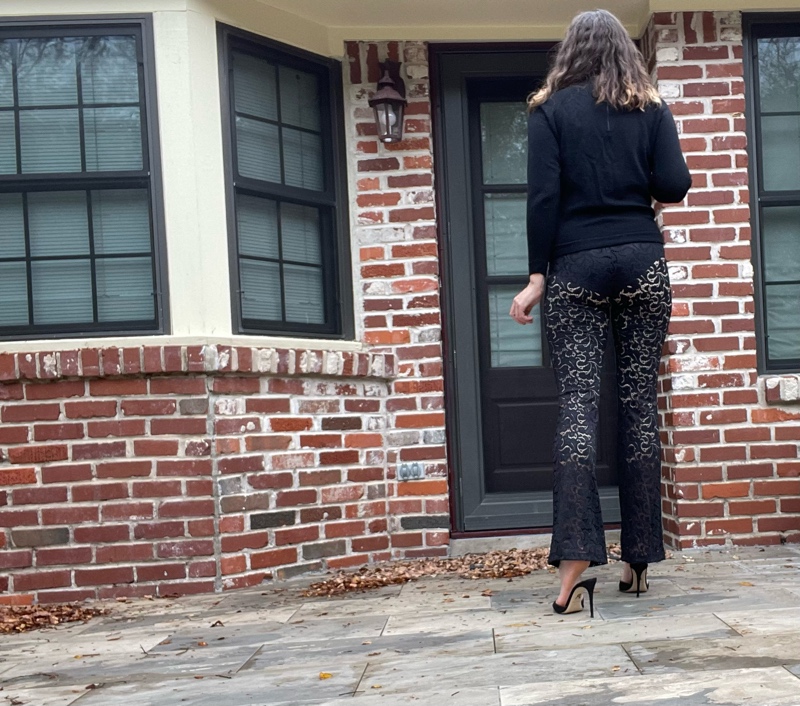 a woman in a black turtleneck, black sheer lace pants and black peep toe heels