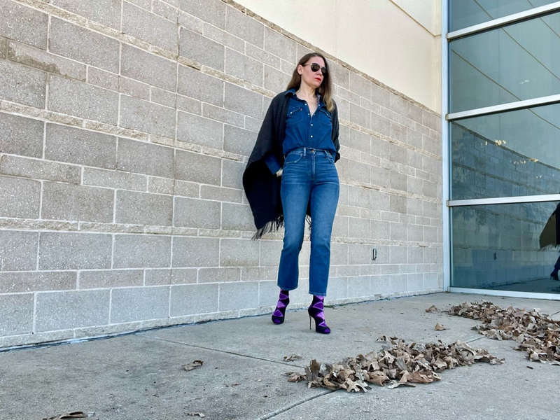 a woman in a denim shirt and jeans with socks, peep toe heels and a grey wool wrap