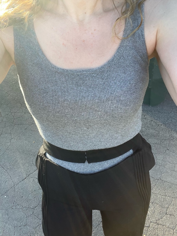 a woman in a grey sweater tank with black wool split waist pants and black heels