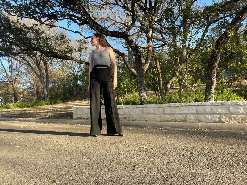 a woman in a grey sweater tank with black wool split waist pants and black heels