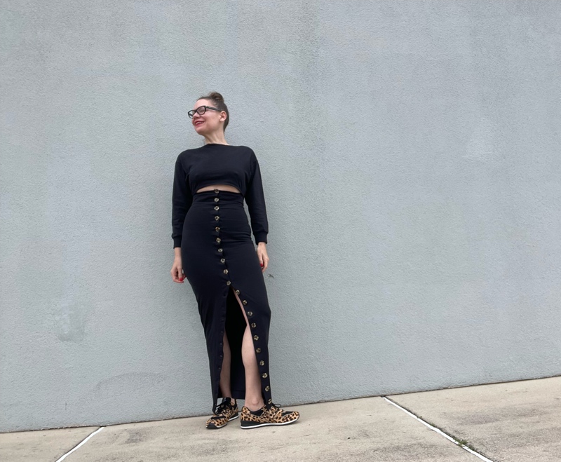 a woman in a jersey dress with a waist cut out and button skirt with leopard sneakers