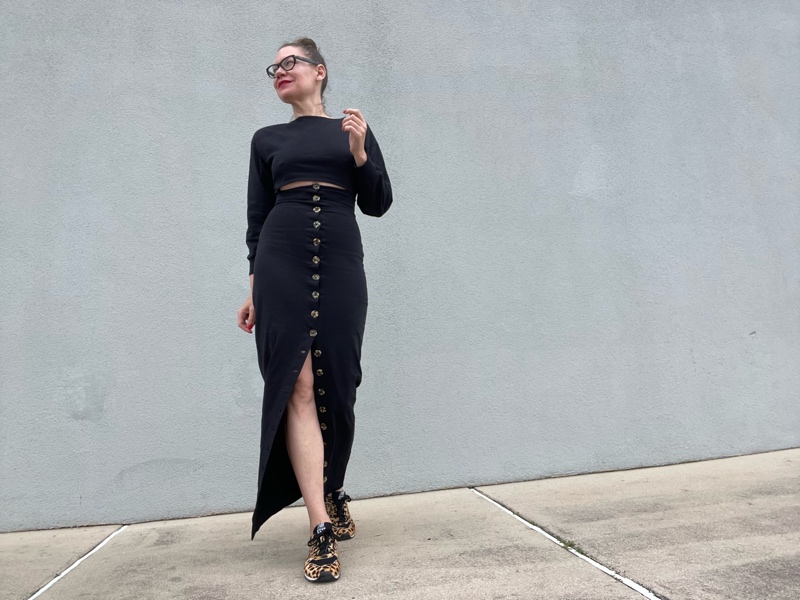 a woman in a jersey dress with a waist cut out and button skirt with leopard sneakers