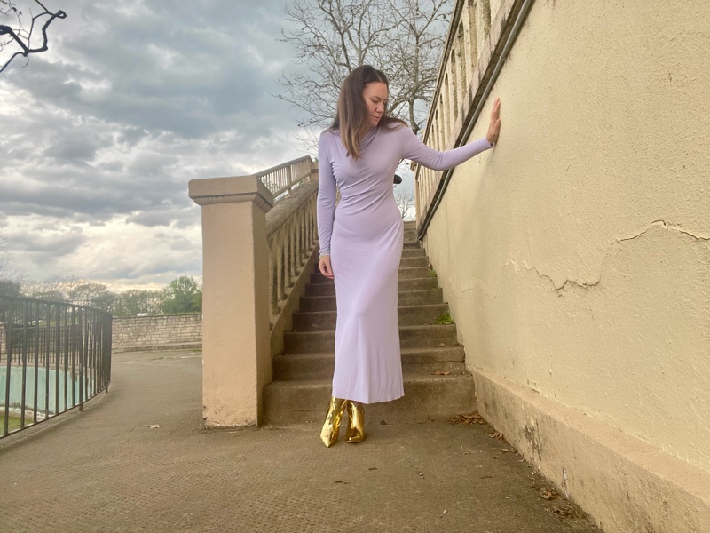 a woman in a lavender maxi dress and gold wedge boots