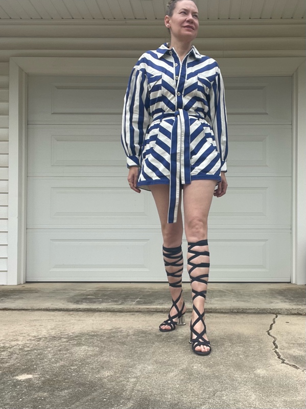 a woman in a blue and white striped short romper with blue lace up sandals 